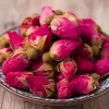 The dried roses are tightly closed in shades of deep crimson red, sometimes with a few loose petals or the occasional brown bud.